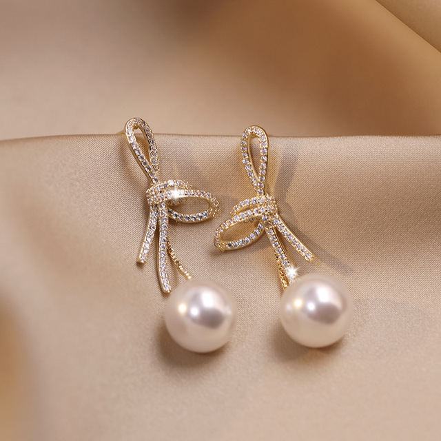 Boucles d'oreilles perles avec un nœud brillant doré